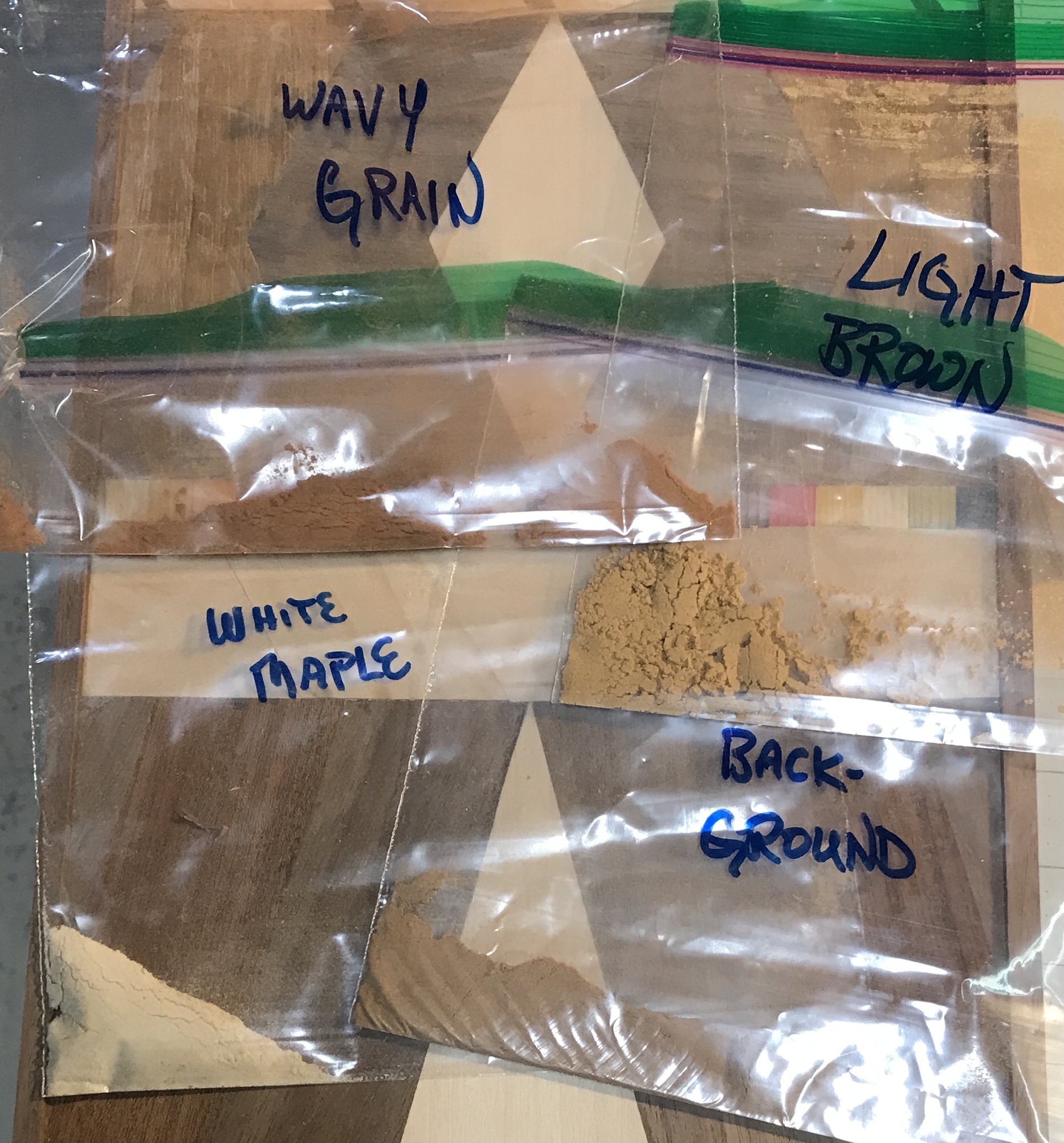 Four bags of sawdust made from four different types of veneer.